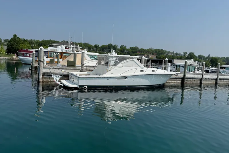 Slide: The Image of 2002 Pursuit 3800 Express yacht docked at a marina, reflecting on calm water. - 16