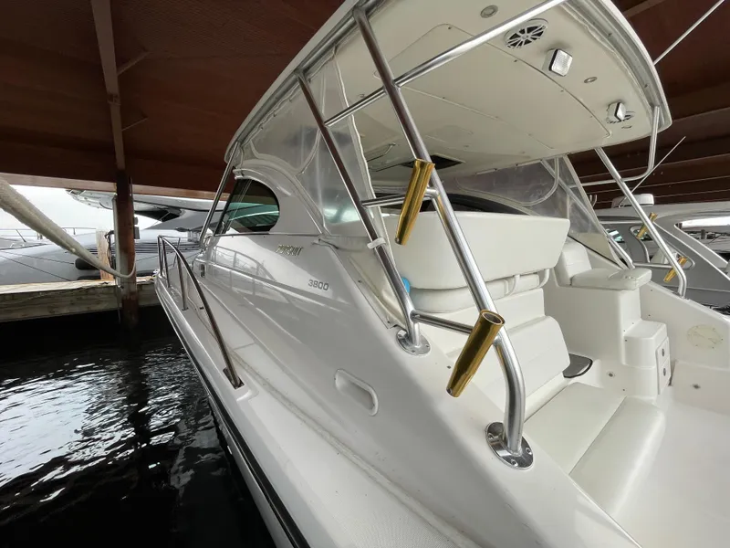 Slide: The Image of 2002 Pursuit 3800 Express boat docked under a wooden shelter. - 19