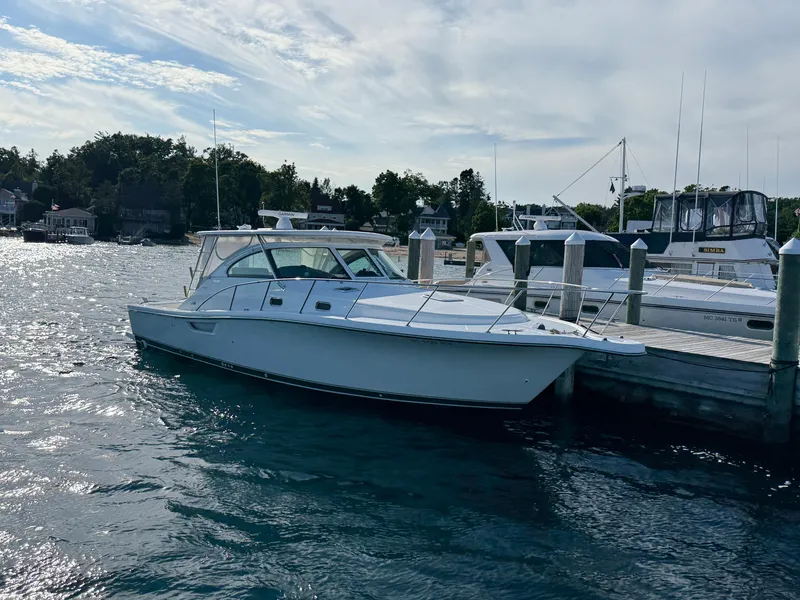 Slide: The Image of 2002 Pursuit 3800 Express yacht docked at marina, calm water, clear sky. - 2