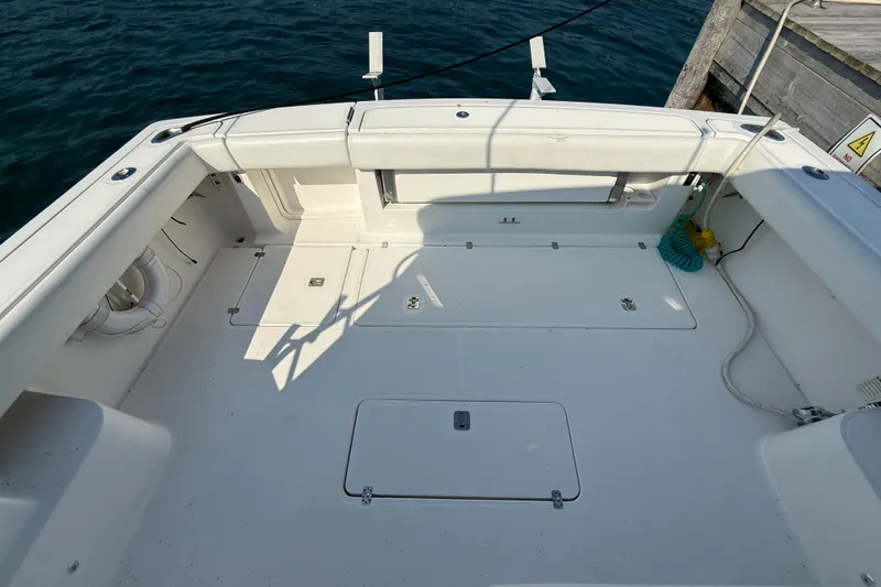 Slide: The Image of Spacious deck of 2002 Pursuit 3800 Express boat, docked by the water. - 20