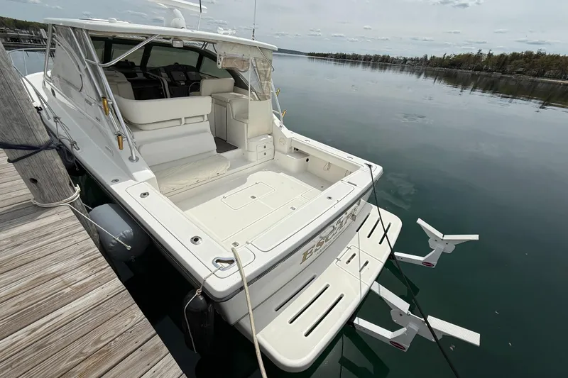 Slide: The Image of 2002 Pursuit 3800 Express boat docked on calm water, showcasing spacious deck and seating area. - 21
