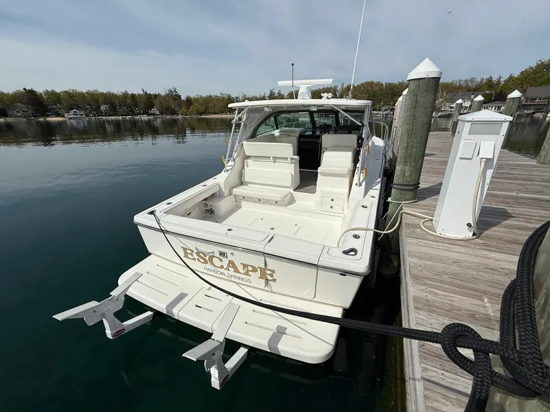 Slide: The Image of 2002 Pursuit 3800 Express boat docked at a marina, rear view. - 22