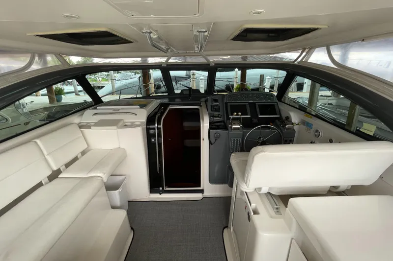 Slide: The Image of Interior of 2002 Pursuit 3800 Express yacht with white seating and modern helm. - 23