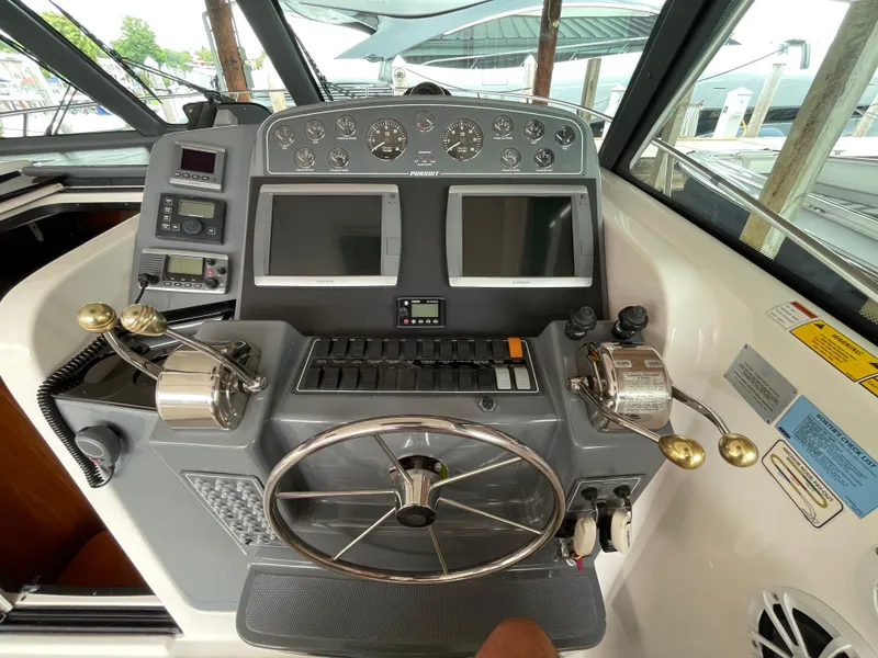 Slide: The Image of Control panel of a 2002 Pursuit 3800 Express boat with steering wheel and gauges. - 28