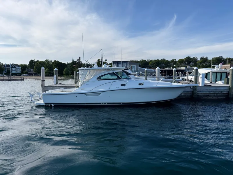 Slide: The Image of 2002 Pursuit 3800 Express yacht docked at a marina on a sunny day. - 3