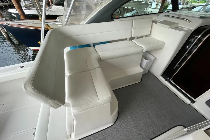 Slide: The Image of 2002 Pursuit 3800 Express boat interior with white seating and carpeted floor. - 31