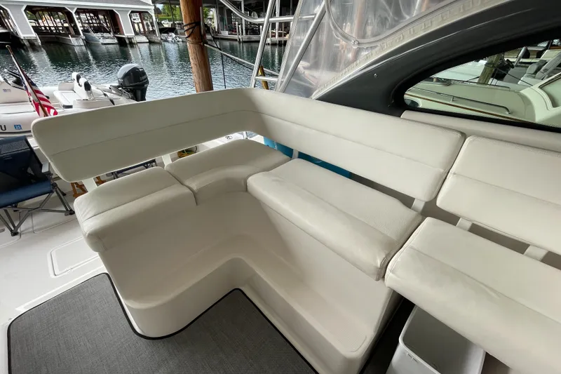 Slide: The Image of 2002 Pursuit 3800 Express boat with white cushioned seating, docked near water. - 32