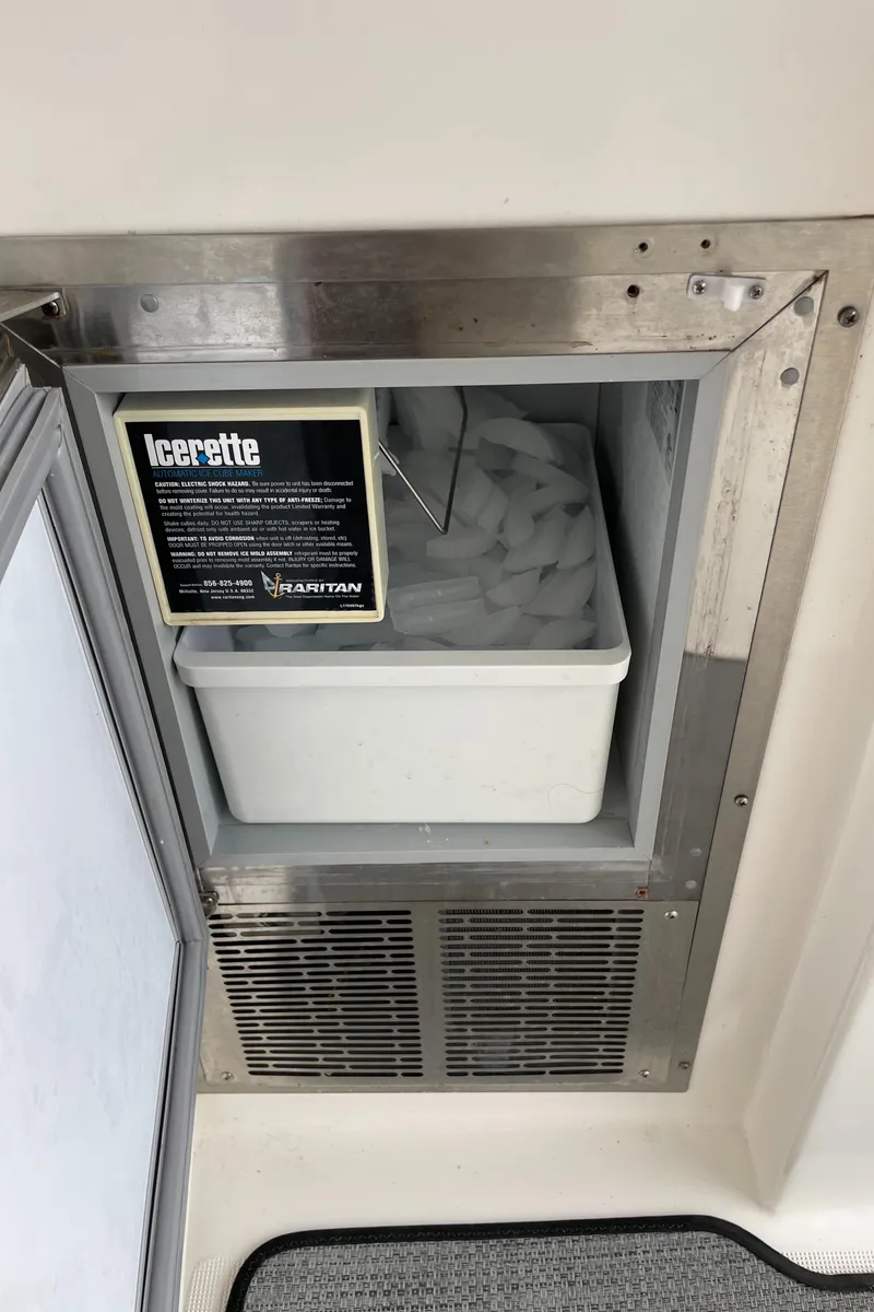 Slide: The Image of Ice maker on a 2002 Pursuit 3800 Express boat, featuring a stainless steel finish. - 34
