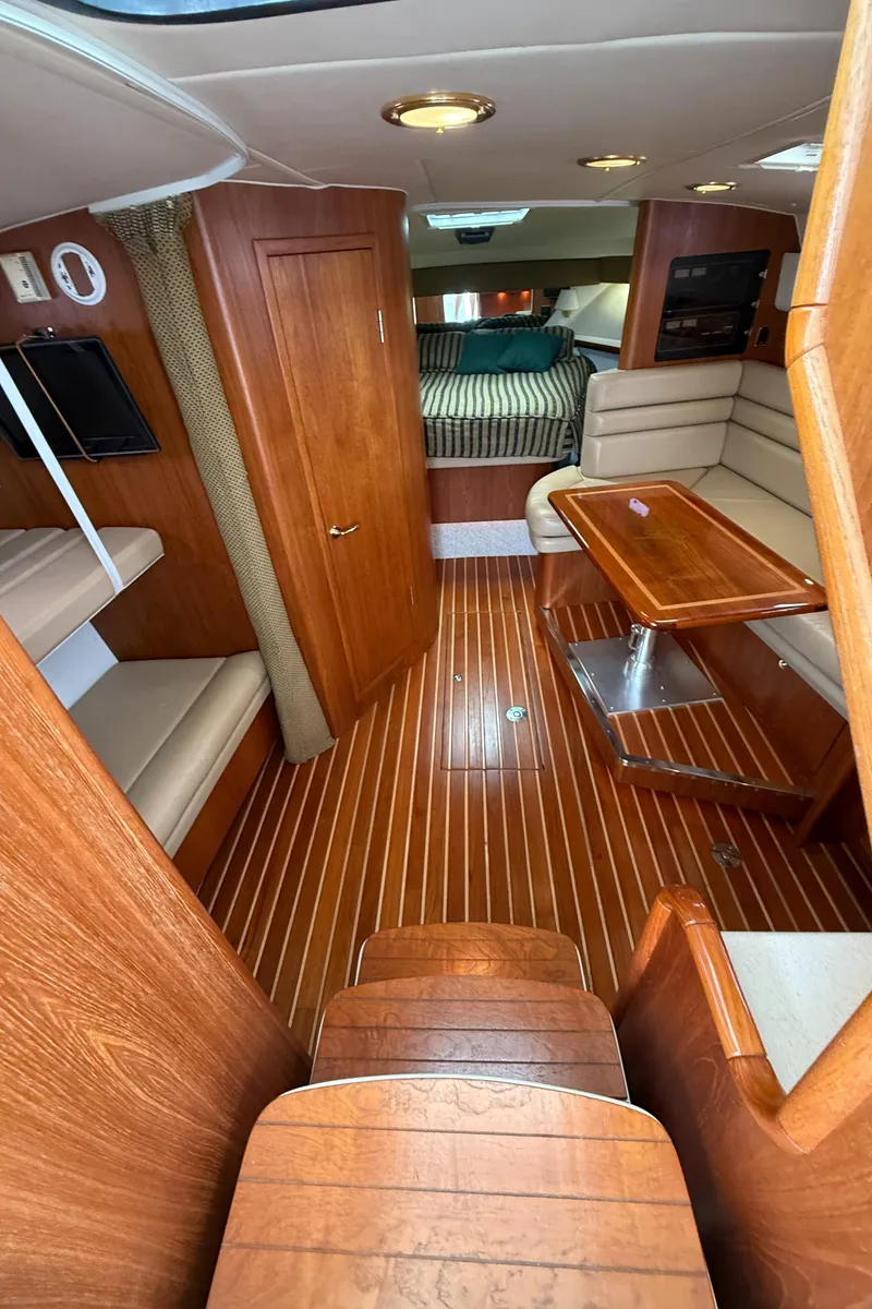 Slide: The Image of Interior of 2002 Pursuit 3800 Express boat with wood flooring and seating area. - 37