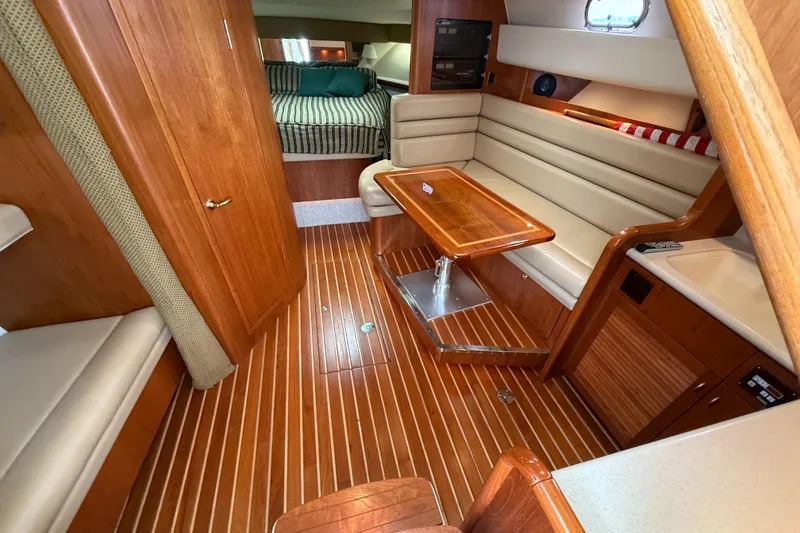 Slide: The Image of Interior of 2002 Pursuit 3800 Express yacht with wood flooring and cozy seating area. - 38