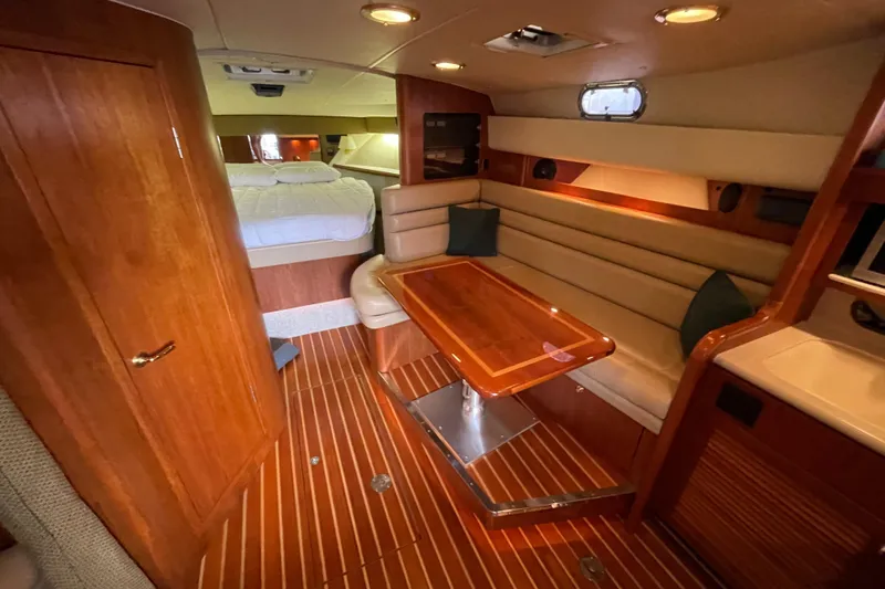 Slide: The Image of Interior of 2002 Pursuit 3800 Express yacht with wood finishes and cozy seating area. - 39