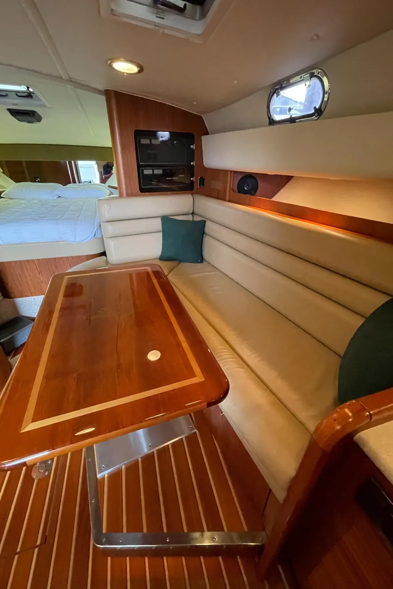 Slide: The Image of Interior of a 2002 Pursuit 3800 Express yacht with elegant wood and beige seating. - 45