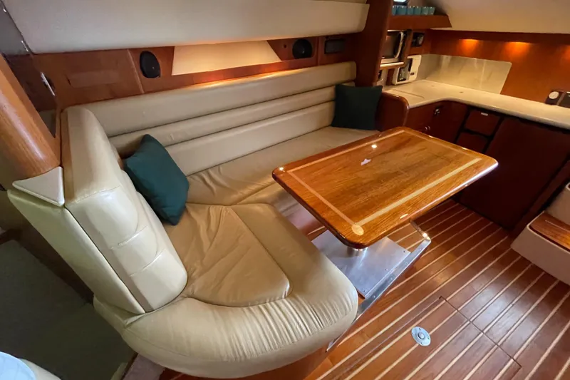 Slide: The Image of Luxurious interior of 2002 Pursuit 3800 Express yacht with leather seating and wooden table. - 49