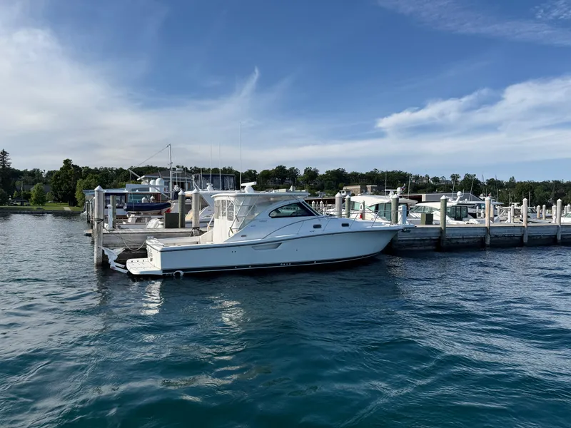 Slide: The Image of 2002 Pursuit 3800 Express yacht docked at a marina under a clear blue sky. - 8