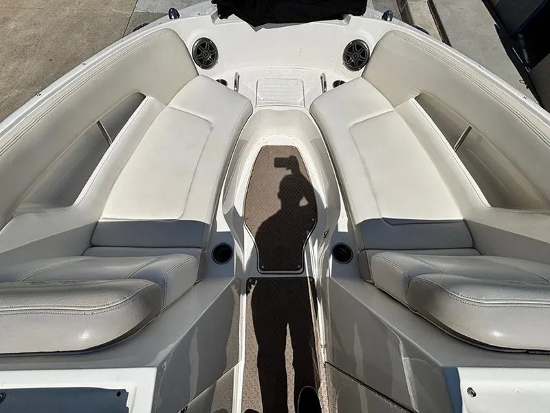 Slide: The Image of 2013 Sea Ray 240 Sundeck interior with white seating and speaker system. - 19