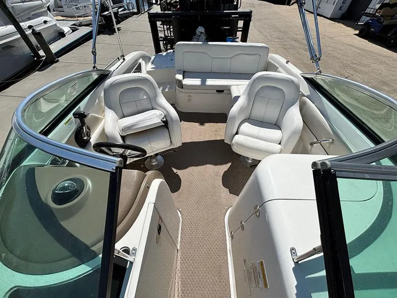 Slide: The Image of 2013 Sea Ray 240 Sundeck interior with white seating and steering wheel. - 22