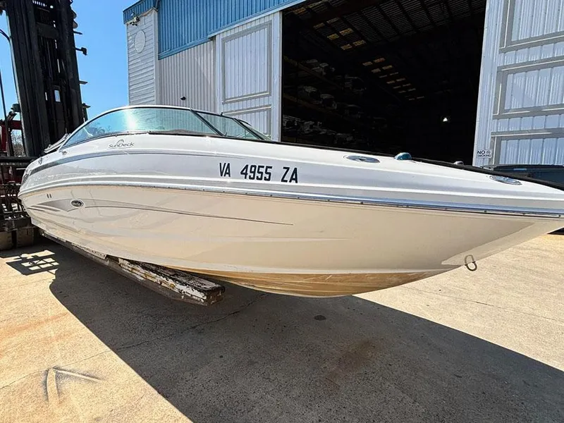 Slide: The Image of 2013 Sea Ray 240 Sundeck boat on a trailer outside a warehouse. - 3