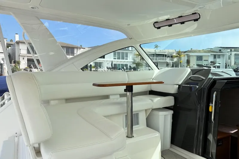 Slide: The Image of 2020 Tiara Yachts 3900 Open "Coronet" interior with white seating and wooden table. - 14