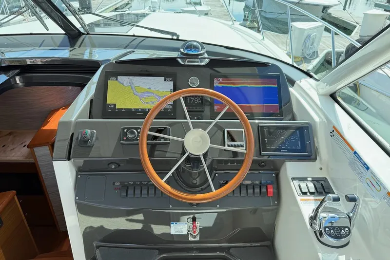Slide: The Image of Helm of 2020 Tiara Yachts 3900 Open "Coronet" with navigation screens and wooden steering wheel. - 16
