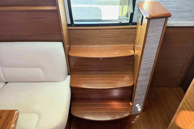 Slide: The Image of Interior of 2020 Tiara Yachts 3900 Open "Coronet" with wooden steps and white seating. - 26
