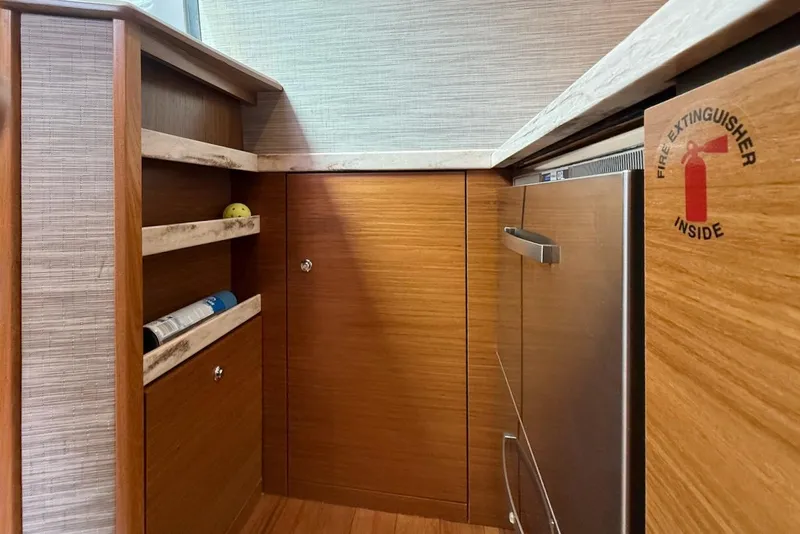 Slide: The Image of 2020 Tiara Yachts 3900 Open Coronet interior with wood cabinetry and fire extinguisher sign. - 33