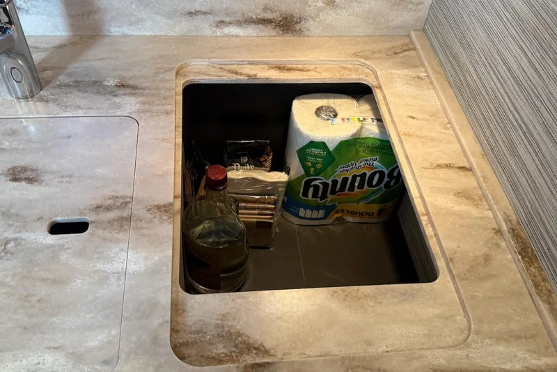 Slide: The Image of Storage compartment in 2020 Tiara Yachts 3900 Open, containing paper towels and groceries. - 36