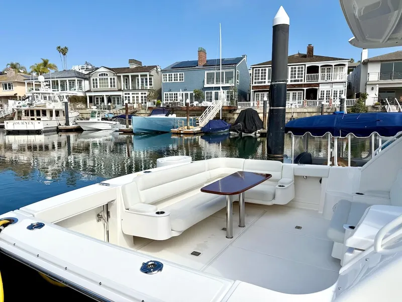 Slide: The Image of 2020 Tiara Yachts 3900 Open "Coronet" docked, featuring spacious seating and waterfront homes. - 4