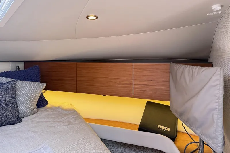 Slide: The Image of 2020 Tiara Yachts 3900 Open "Coronet" cabin interior with cozy bedding and wooden cabinets. - 41
