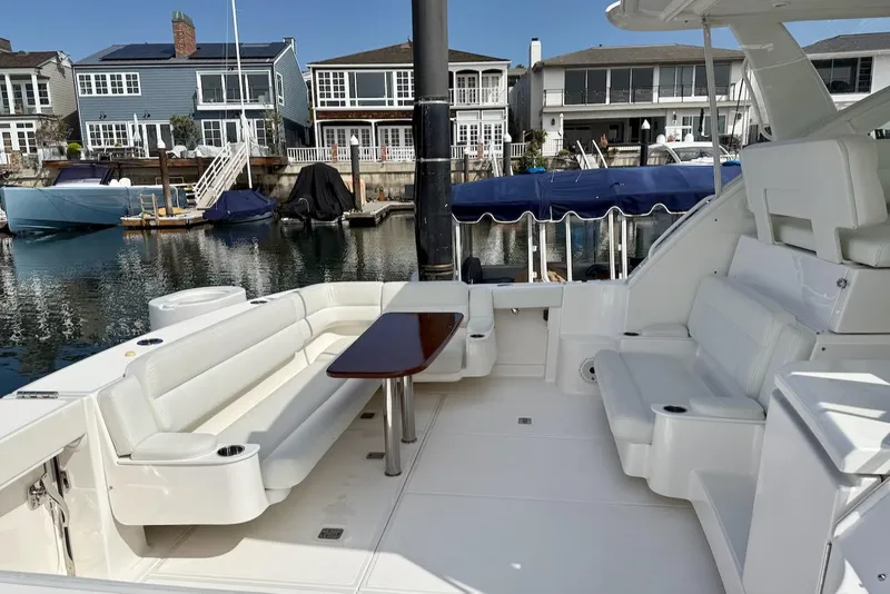 Slide: The Image of 2020 Tiara Yachts 3900 Open "Coronet" with white seating, docked near waterfront homes. - 5