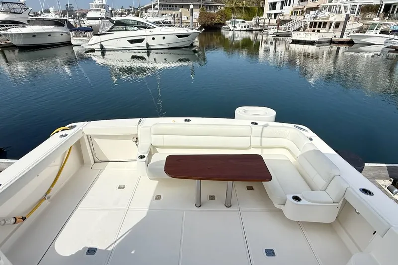 Slide: The Image of 2020 Tiara Yachts 3900 Open "Coronet" with spacious deck and seating in marina. - 8