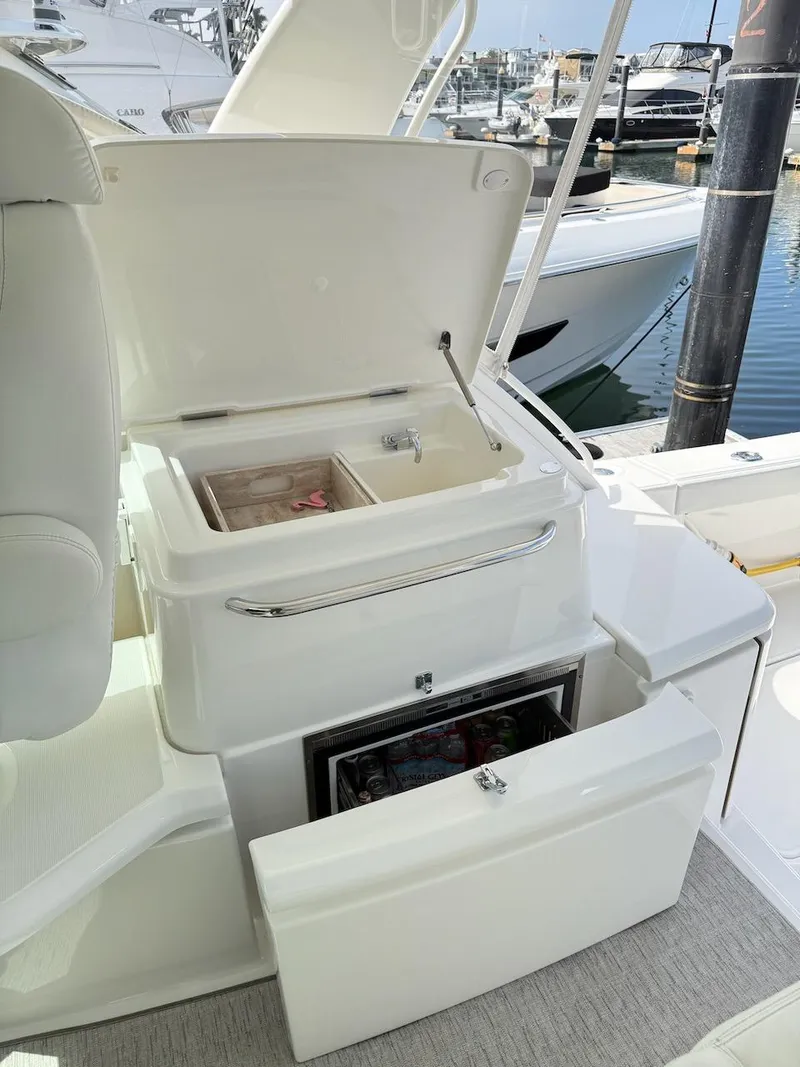 Slide: The Image of 2020 Tiara Yachts 3900 Open "Coronet" with open storage compartments at marina. - 9