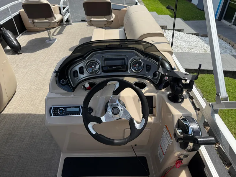 Slide: The Image of 2019 Sun Tracker Fishin' Barge 24 DLX dashboard with steering wheel and controls. - 11