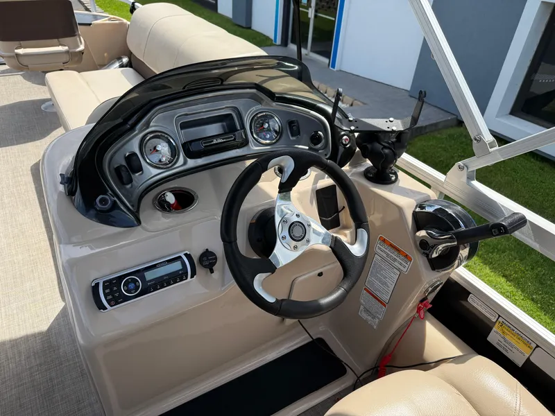 Slide: The Image of 2019 Sun Tracker Fishin' Barge 24 DLX dashboard with steering wheel and controls. - 12