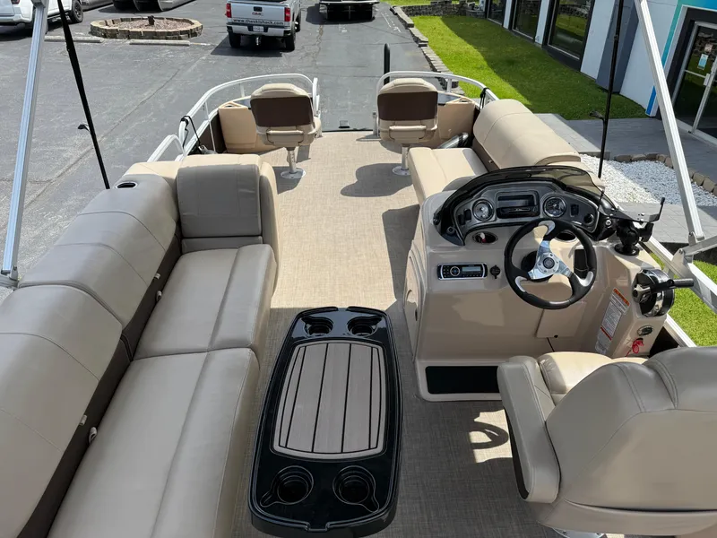 Slide: The Image of 2019 Sun Tracker Fishin' Barge 24 DLX interior with beige seating and control console. - 14