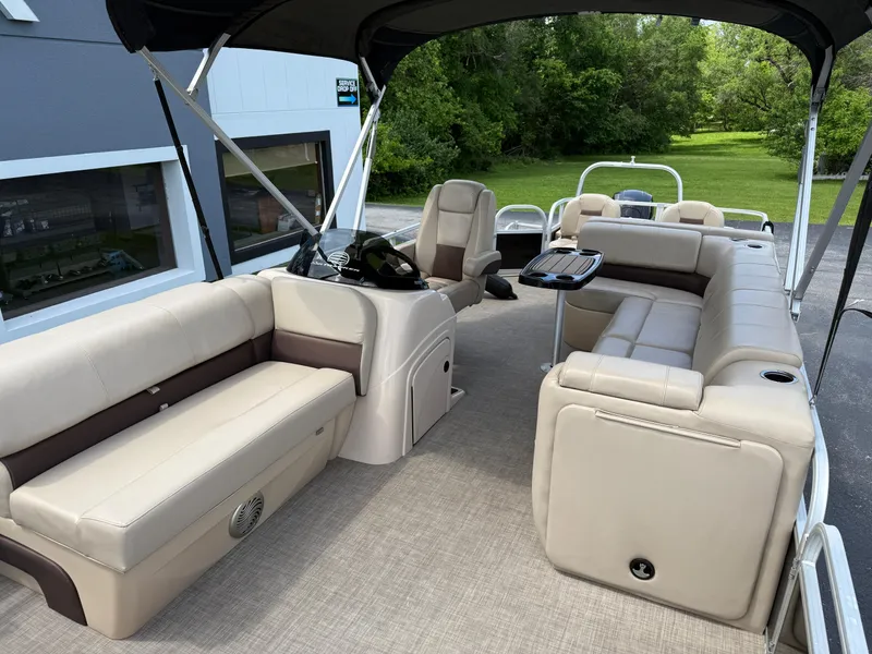 Slide: The Image of 2019 Sun Tracker Fishin' Barge 24 DLX interior with beige seating and modern amenities. - 7