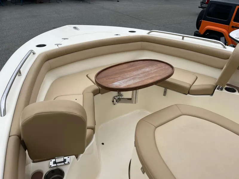 Slide: The Image of 2020 Scout 215 XSF boat interior with beige seating and wooden table. - 14