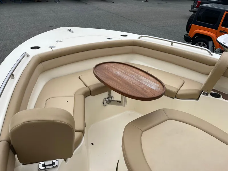 Slide: The Image of 2020 Scout 215 XSF boat interior with beige seating and wooden table. - 15
