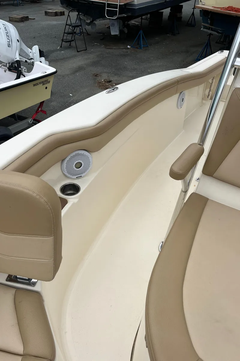 Slide: The Image of 2020 Scout 215 XSF boat interior with beige seating and built-in speakers. - 18