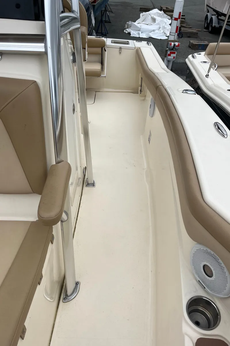 Slide: The Image of 2020 Scout 215 XSF boat interior with beige seating and stainless steel accents. - 19
