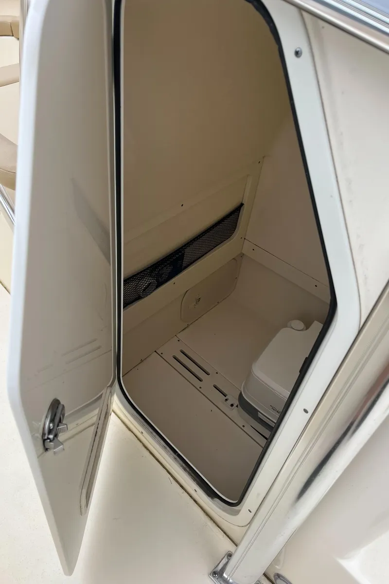 Slide: The Image of 2020 Scout 215 XSF boat interior storage compartment with open door. - 20