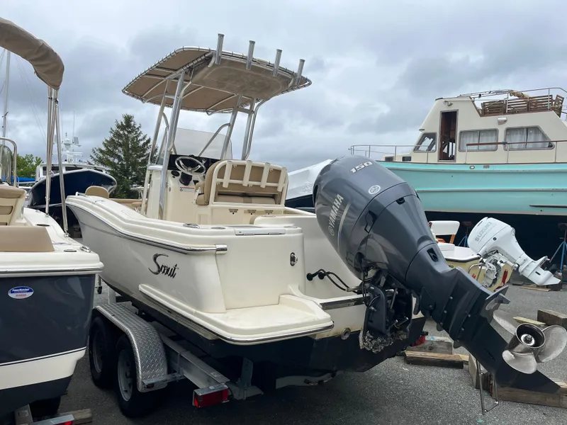 Slide: The Image of 2020 Scout 215 XSF boat on trailer with outboard motor, parked in marina. - 4