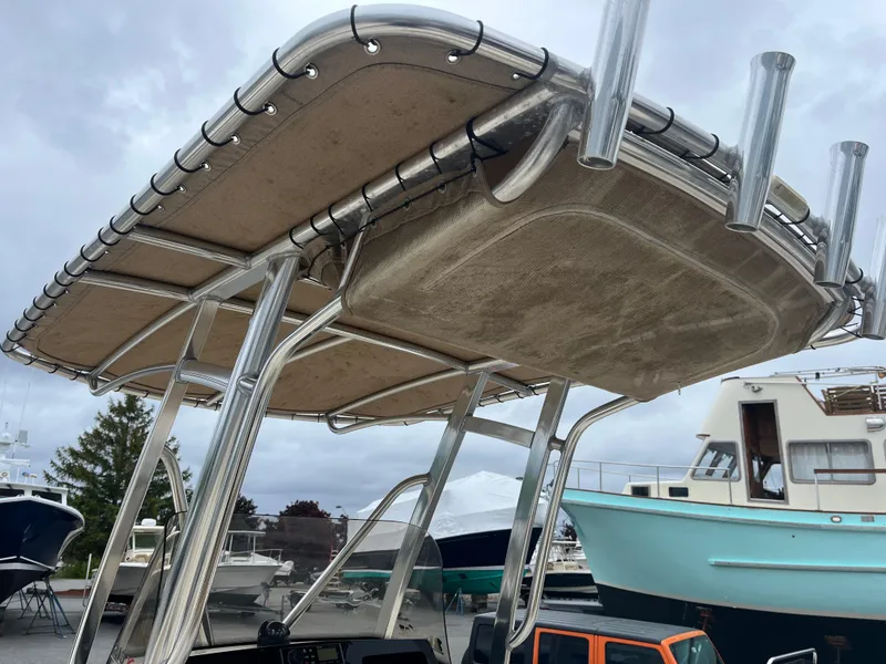 Slide: The Image of 2020 Scout 215 XSF boat with T-top and rod holders, docked near other boats. - 8