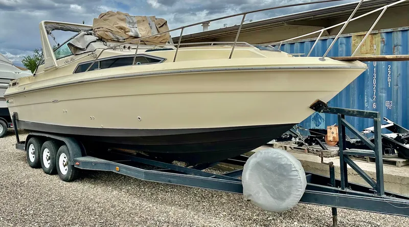 Slide: The Image of 1987 Sea Ray 270 Sundancer boat on trailer, parked outdoors. - 1