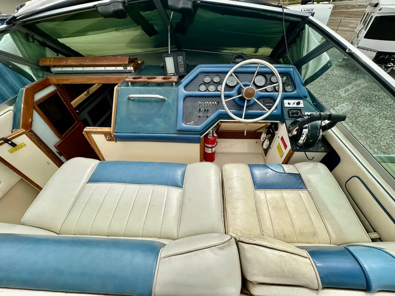 Slide: The Image of 1987 Sea Ray 270 Sundancer boat interior with blue and white seating, steering wheel, and control panel. - 11