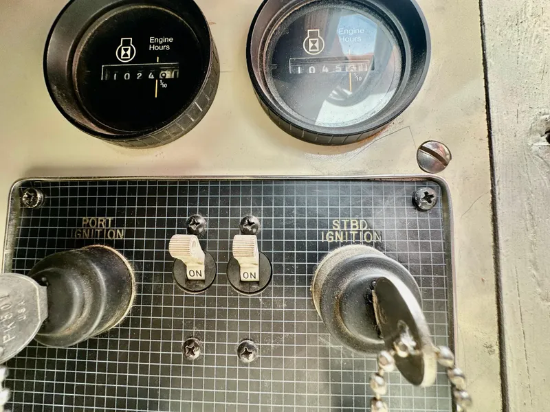 Slide: The Image of Dashboard of a 1987 Sea Ray 270 Sundancer boat with ignition switches and engine hour meters. - 13