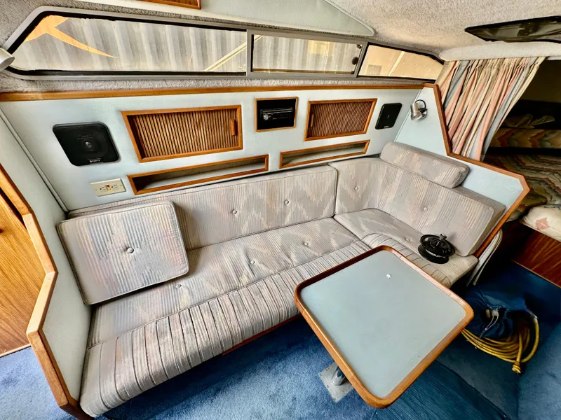 Slide: The Image of Interior of 1987 Sea Ray 270 Sundancer with striped seating and compact table. - 15