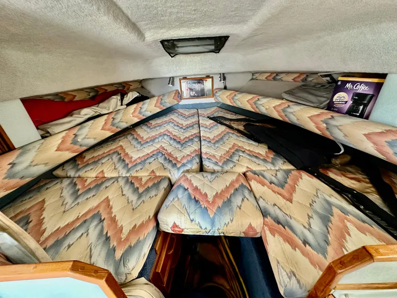 Slide: The Image of 1987 Sea Ray 270 Sundancer cabin with patterned upholstery and cozy sleeping area. - 17