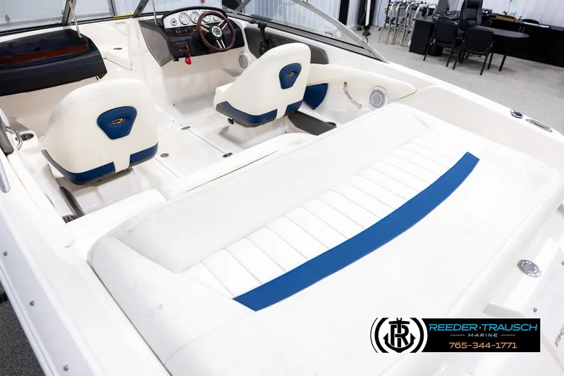Slide: The Image of 2008 Regal 1900 boat interior with white and blue seating, steering wheel, and dashboard. - 11