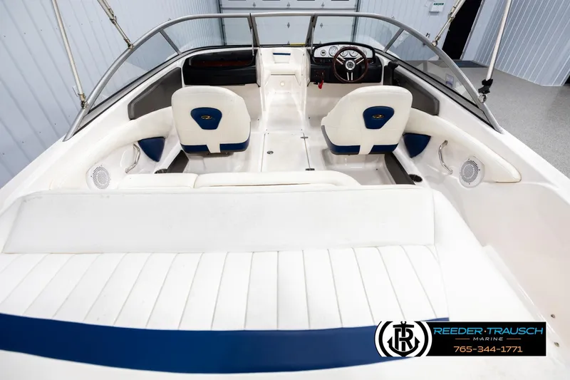 Slide: The Image of 2008 Regal 1900 boat interior with white and blue seating, steering wheel, and dashboard. - 13