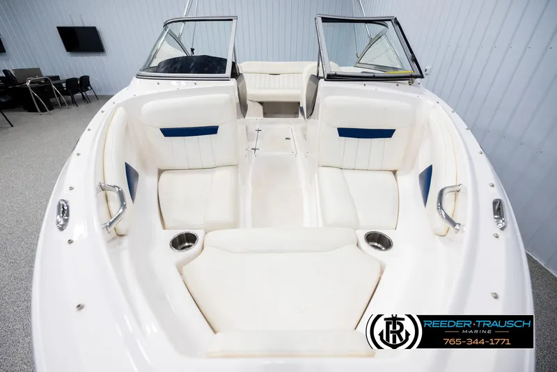 Slide: The Image of 2008 Regal 1900 boat interior with white seating and blue accents in showroom. - 17